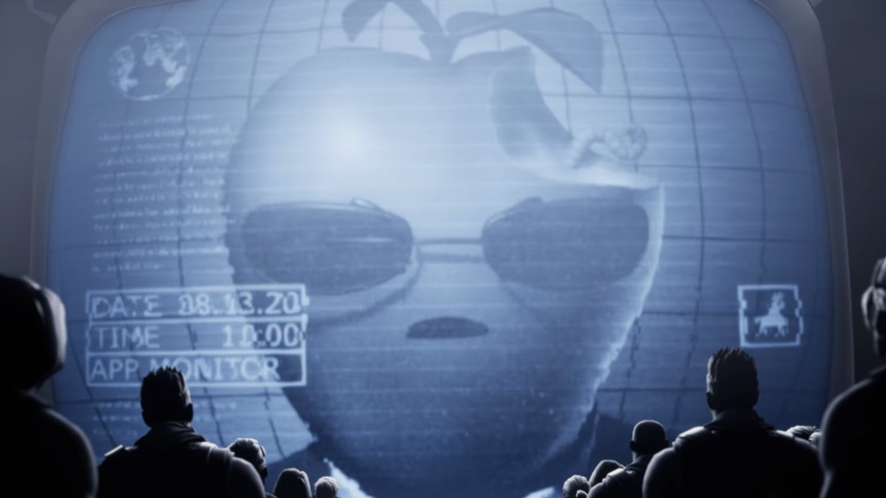 A large screen displays an apple with sunglasses and a worm, watched by silhouetted figures seated below.